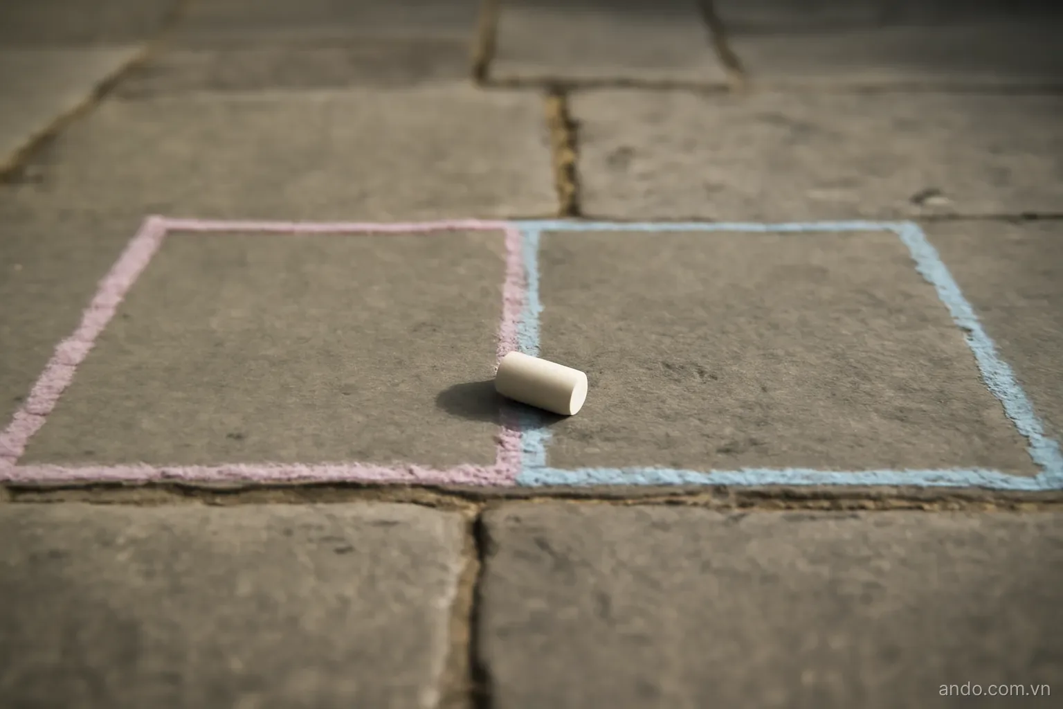 Two adjacent chalk-drawn zones on a stone floor with a single small object placed on the dividing line, no text