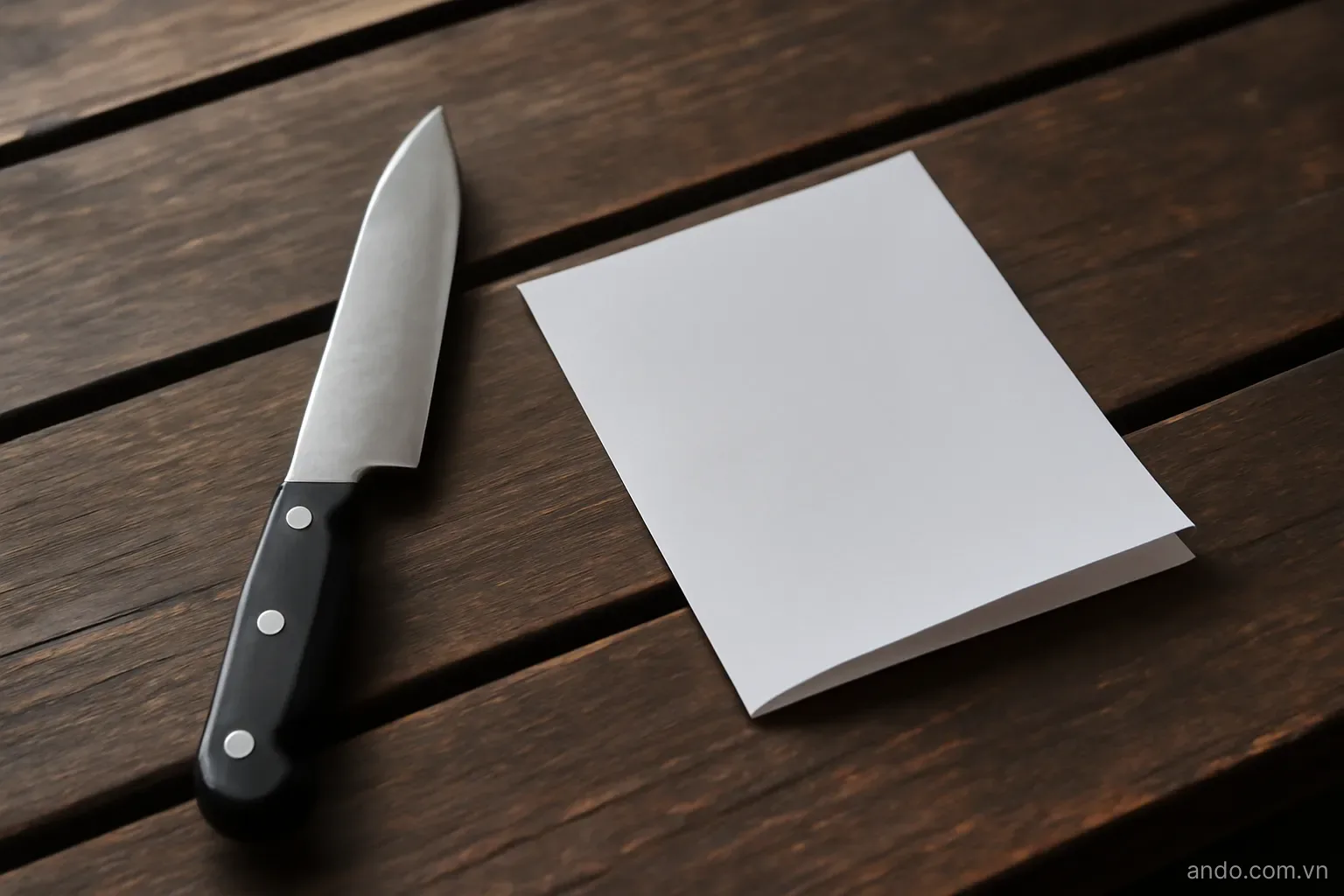 A plain steel blade and a folded blank sheet of paper lying side by side on a worn wooden bench, side light, no text