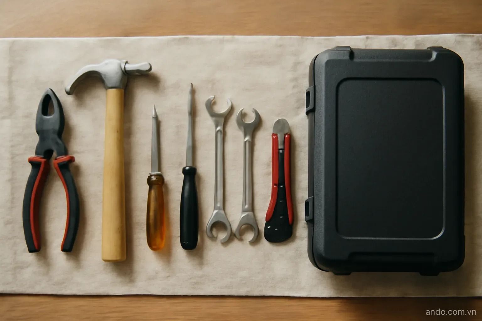 A set of tools laid out in order on a cloth beside a closed travel case, overhead view, no text