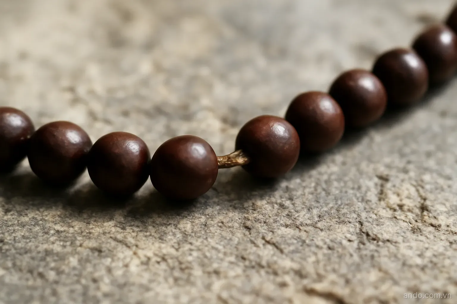A threaded cord with one bead missing leaving a visible gap in the row, close view on stone, no text