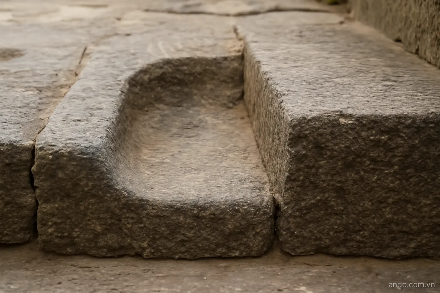 A worn stone step with a smooth hollow in the middle beside an unworn one, side view, no text